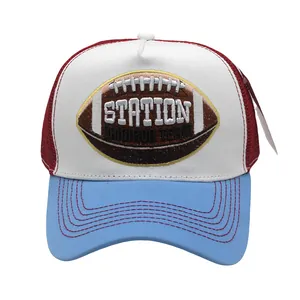 Dettaglio del ricamo a tema rugby sul cappello trucker in rete bianca e rossa sport