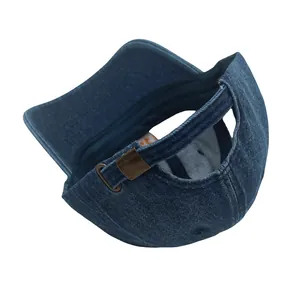 Détail d'une casquette en denim délavé avec trou pour queue de cheval et boucle bronze