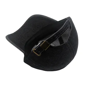 Détail de la casquette en denim noir avec trou pour queue de cheval et boucle en laiton