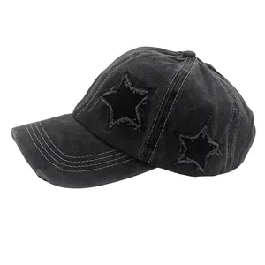 Detail view of washed black baseball cap with star patches and distressed frayed edges