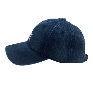 Detail der weißen NYC-Stickerei auf dunkelblauer Jeans-Baseballkappe mit gebogenem Schirm