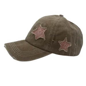 Detail of washed cotton baseball cap featuring pink sequin star patch and frayed edges