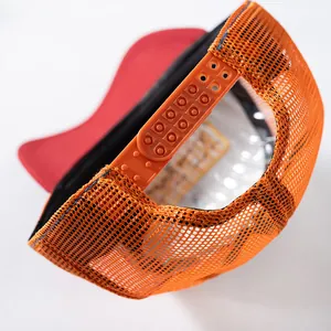 Close-up of adjustable plastic strap and orange mesh detail on a vintage baseball cap