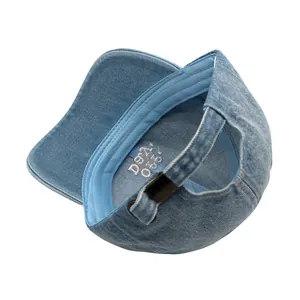 Détail de la casquette en jean délavé avec boucle réglable et broderie interne délicate