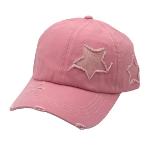 Detail of pink washed cotton baseball cap with distressed brim and glitter star patch