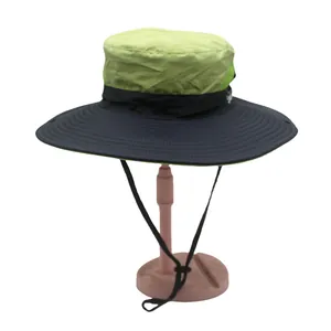 Detail of outdoor sun hat with quick-dry green fabric and black brim with adjustable cord