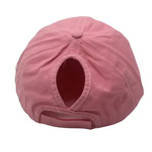 Detail view of pink washed cotton ponytail baseball cap showing rear velcro strap and opening