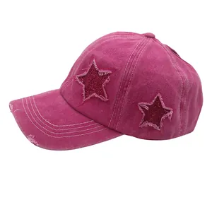 Detail of rose pink baseball cap with distressed brim and sequin star patch design