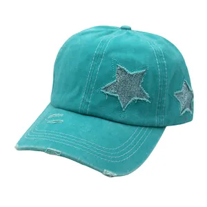 Detail of distressed ponytail baseball cap with glitter star patch and frayed edge