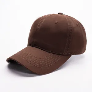 Detail view of the brown cotton baseball cap showing reinforced seams and top button