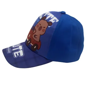 Detalle de gorra azul para niños con dibujo de un simpático carpincho conduciendo un coche