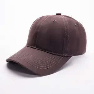 Detail of dark brown cotton baseball cap showing twill fabric and reinforced stitching