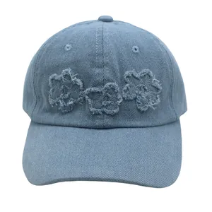 Détails de la casquette en denim délavé avec motifs de fleurs aux bords effilochés