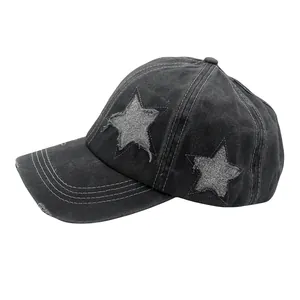 Close-up of washed black baseball cap featuring sequin stars and distressed fraying