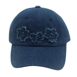 Gros plan détaillé de la casquette en jean bleu foncé avec patchs floraux rétro effilochés