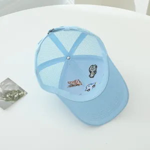 Détail de la broderie voiture et maille respirante sur la casquette enfant bleu clair