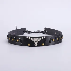 Détail d'un tour de cou en cuir noir avec tête de taureau argentée et rivets dorés