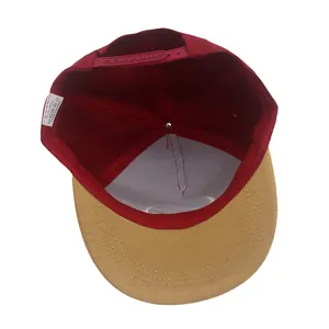 Detail of red snapback cap with adjustable strap and interior 100% acrylic fabric label