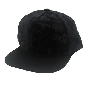 Close-up detail of the 3D embroidered R letter and patterned fabric on the black flat brim hat