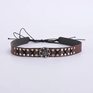 Détail d'un choker punk vintage en cuir PU marron avec clous et boucle métallique