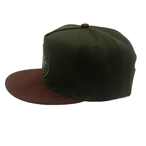Close-up of a compass embroidery patch on a green and brown flat brim snapback hat