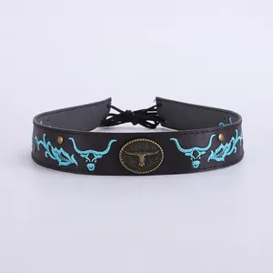 Détail d'un ruban de chapeau en cuir avec broderie longhorn turquoise et badge métallique