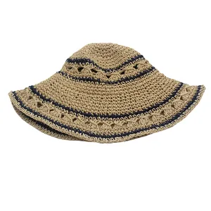 Close-up of foldable straw hat with navy blue stripes and hollow knit patterns