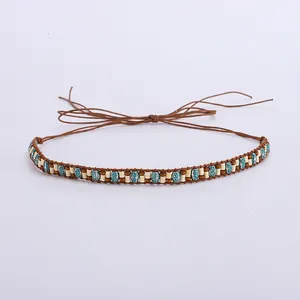 Détail d'un ruban de chapeau bohème perlé avec des accents turquoise et cordon tissé