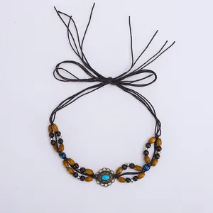 Détail d'un ruban de chapeau ethnique avec fleur en métal turquoise et perles