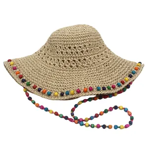 Vue détaillée du tissage de la paille et de la bordure de perles colorées du chapeau d'été