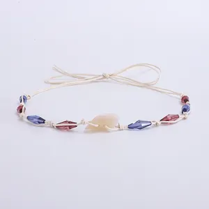 Détail d'un bandeau de chapeau bohème avec perles de cristal violettes et pendentif