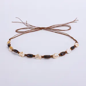 Détail d'un ruban de chapeau bohème avec perles en bois marron et coquillages naturels