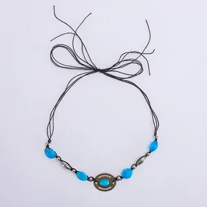 Gros plan du ruban de chapeau bohème avec perles bleues et anneau en bronze