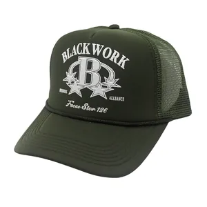 Close-up of military green trucker hat featuring white B letter embroidery and mesh panels