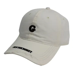 Detailopname van de crème baseballpet met zwarte G-borduring en vintage gerafelde rand