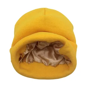 Detalle de gorro de punto amarillo con forro de satén champán para proteger el cabello