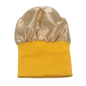 Detalle de gorro de punto amarillo con forro de satén champán para proteger el cabello