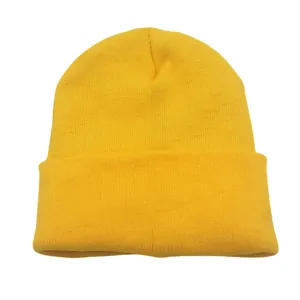 Primer plano detallado del gorro de punto amarillo brillante con textura de canalé y doblez