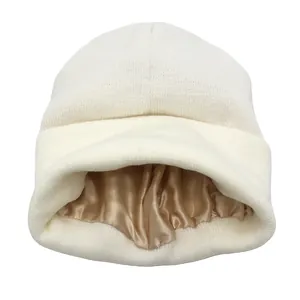 Detalle de gorro de punto blanco con forro de satén champán para la protección del cabello