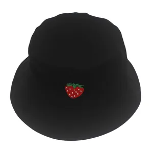 Dettaglio del ricamo a fragola su un cappello a secchiello in cotone nero con cuciture