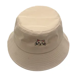 Detailopname van kattenborduurwerk en versterkte stiksels op de beige katoenen vissershoed
