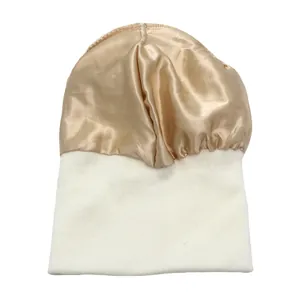 Detalle del forro de satén dorado y el tejido de punto blanco en un gorro de invierno