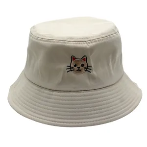 Detailopname van kattenborduurwerk op een beige katoenen twill vissershoed voor de zon