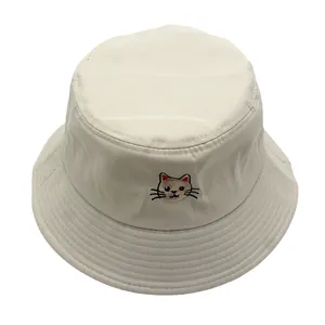 Detailopname van een beige katoenen vissershoed met schattig kattenborduursel vooraan