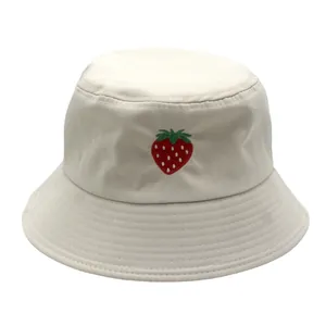 Dettaglio ravvicinato del ricamo a fragola su cappello bucket in cotone bianco