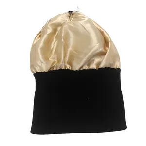 Detalle del exterior de punto negro y el forro de satén dorado del gorro de invierno