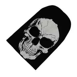Close-up of black knit beanie featuring a white skull pattern for Halloween style