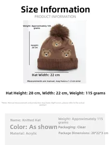 Detail showing brown knit beanie with bear embroidery and soft faux fur pom-pom