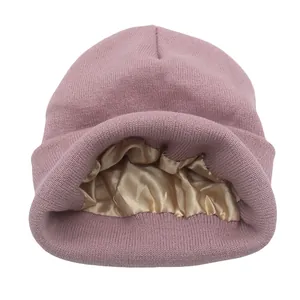 Detalle del gorro de punto rosa con forro de satén dorado para proteger el cabello