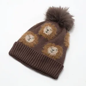 Detailed close-up of cartoon lion patterns and fuzzy pom-poms on children's knit hats